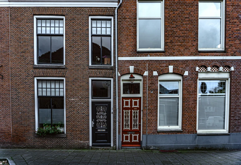 a tall red brick building has windows and doors