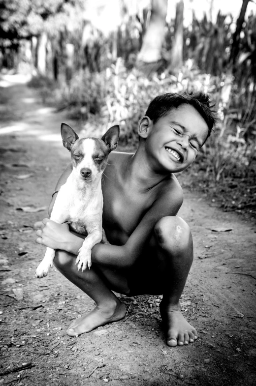 a black and white image of a boy holding a dog