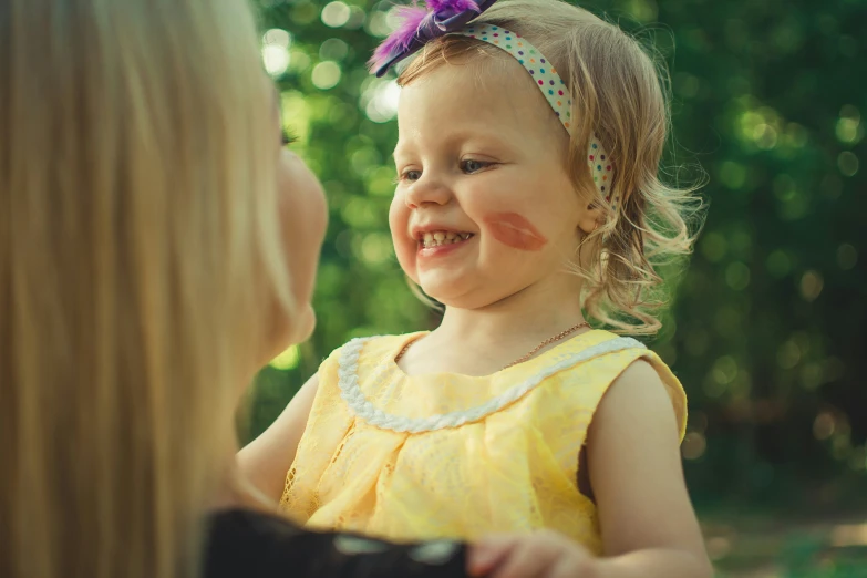 a toddler laughing with a woman looking on