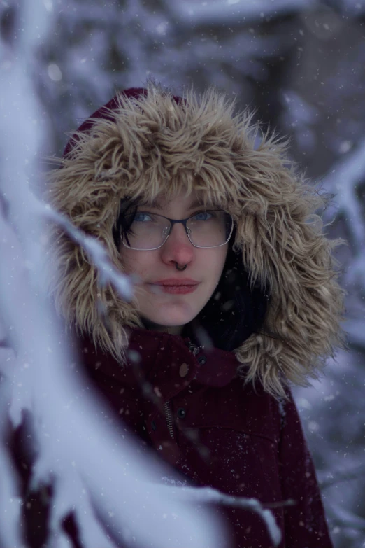 a woman in winter clothes and furry hat in a tree