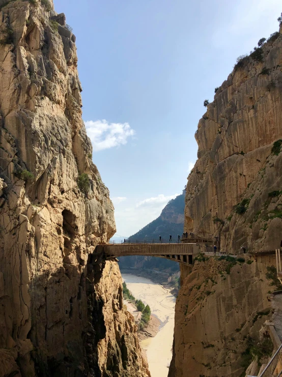 a bridge with an ocean view next to a cliff