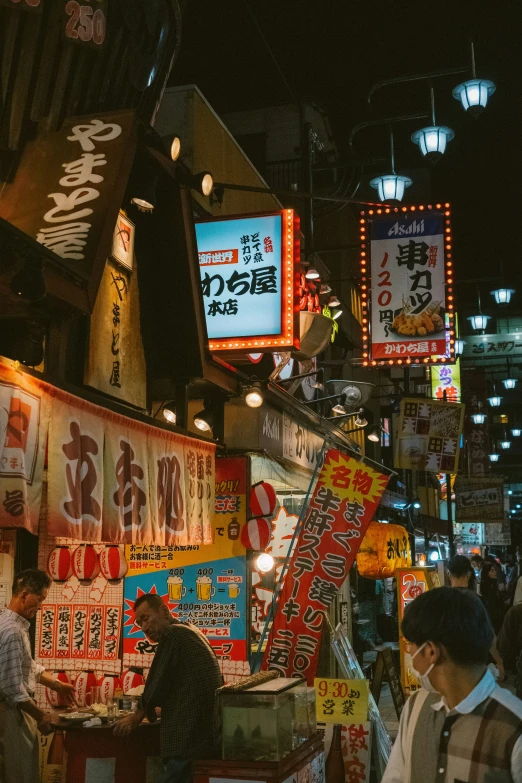 asian street vendors are seen at night near neon signs