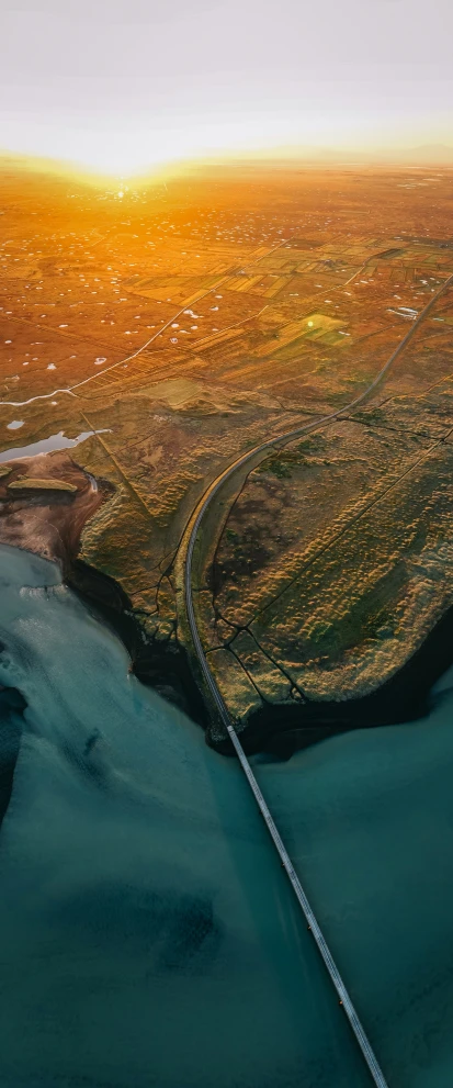 a view of a river, land and city from an airplane