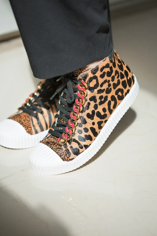 a pair of shoes with leopard print and spikes on the sides