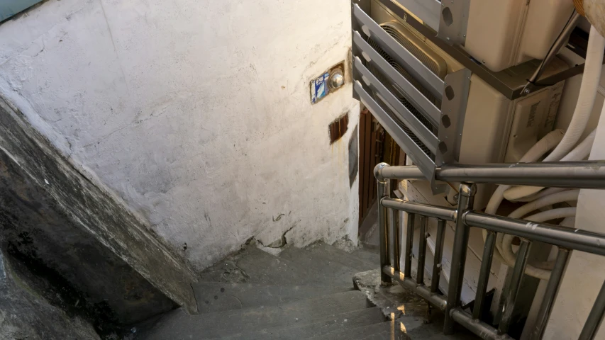 the metal gate on the stairs leads into a toilet stall