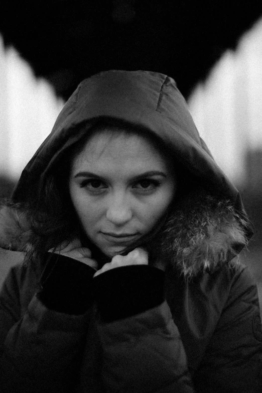 black and white pograph of a woman wearing a hooded jacket