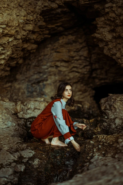 a person kneeling down near some rocks