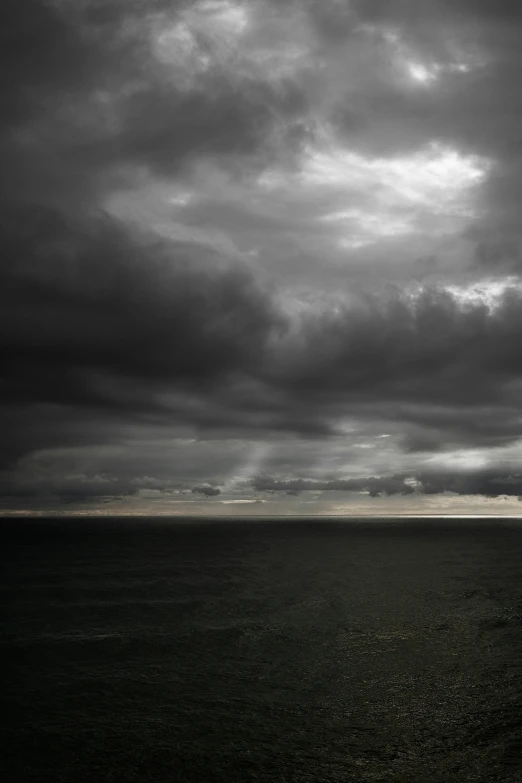 there is a white boat on the ocean near a hill