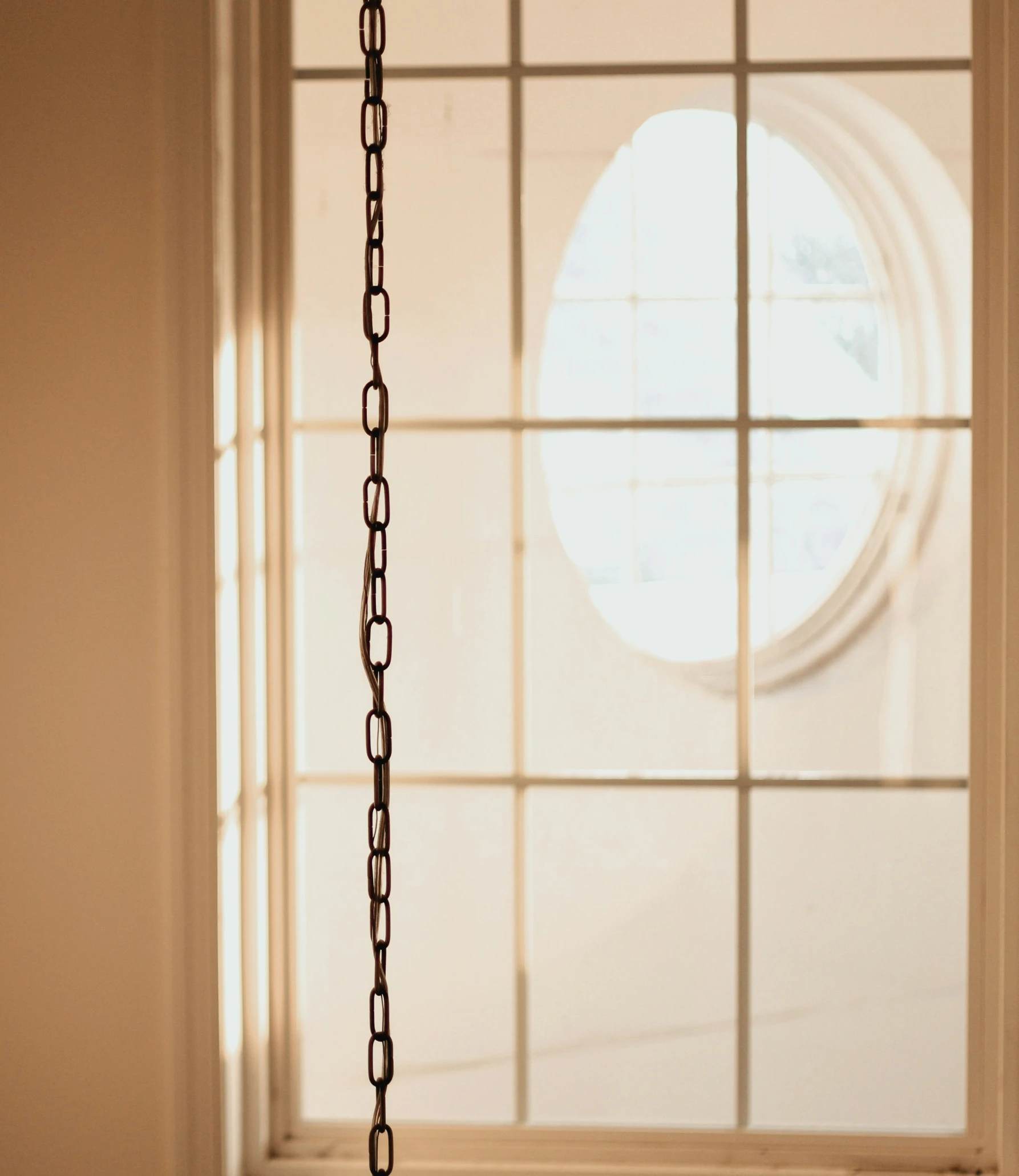 a chain hangs up near an open window