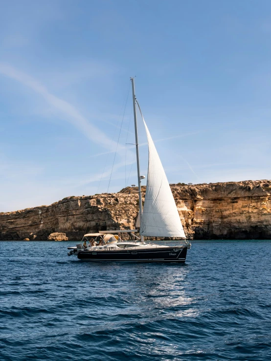 a small sailboat sailing on the blue water