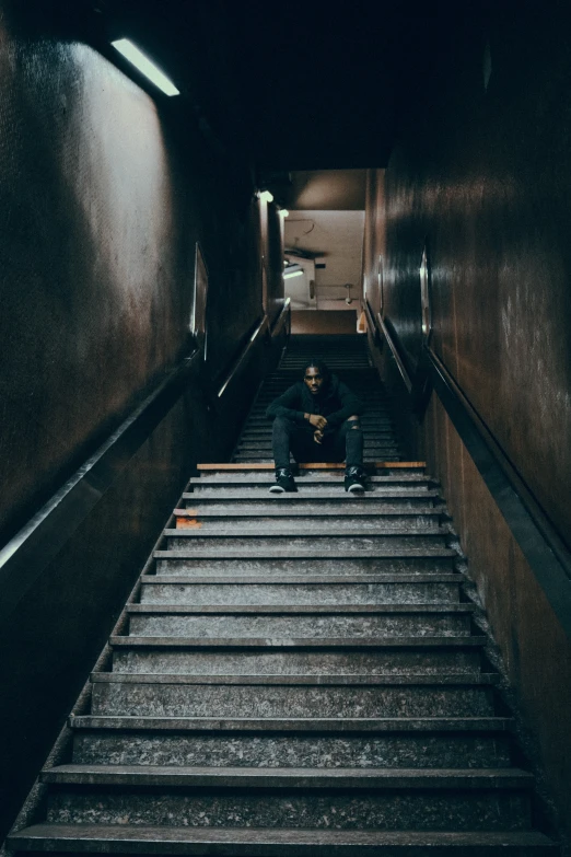 a person sitting on steps in an escalator