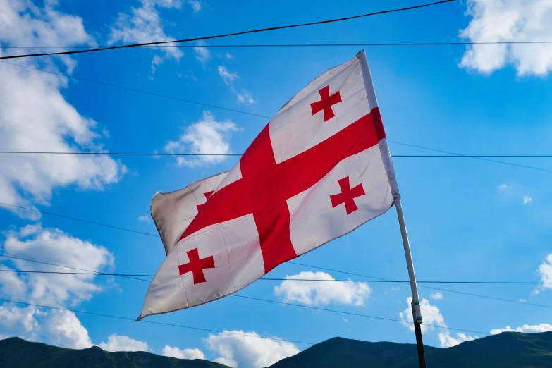 an old flag with the british cross on it flying from a pole