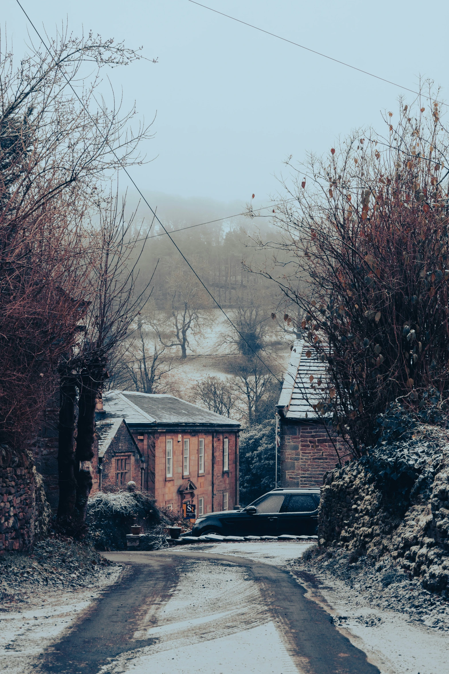 snow covered roads with a house in the background