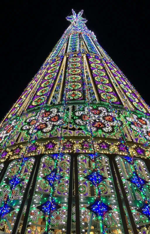 christmas tree lit up at night with very colorful lights