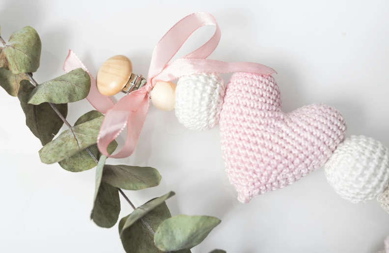 four crocheted ornaments and pink bow attached to the string