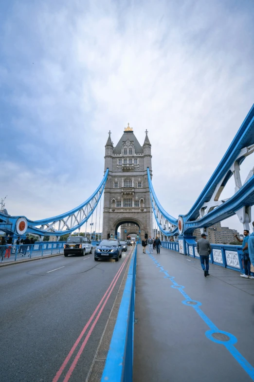 a bridge with cars driving on it and people walking by