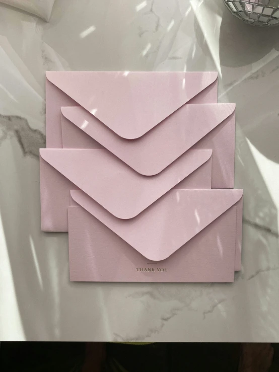 there is a pink envelope that has been folded and on it