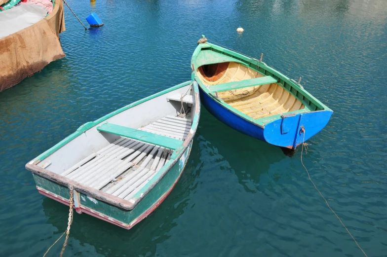 two boats are parked at a dock near one another