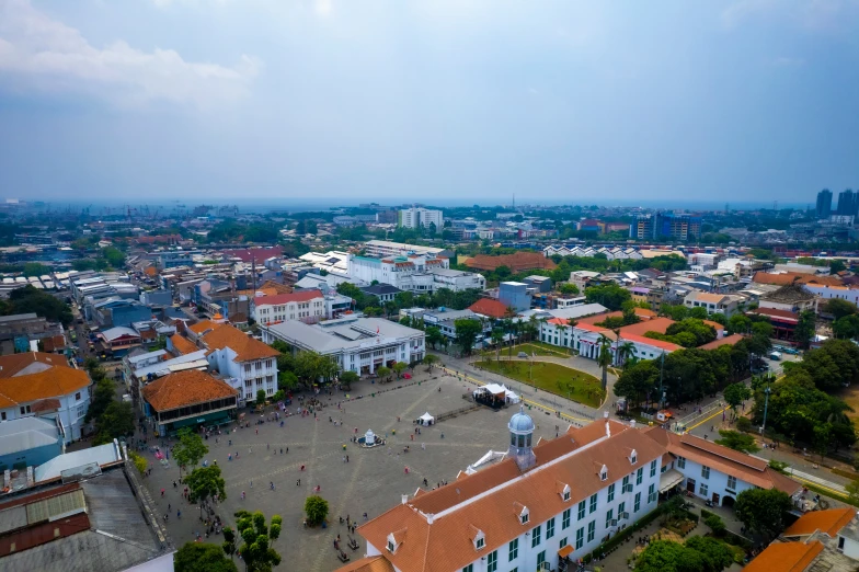 an aerial view shows orange roofs and several white buildings