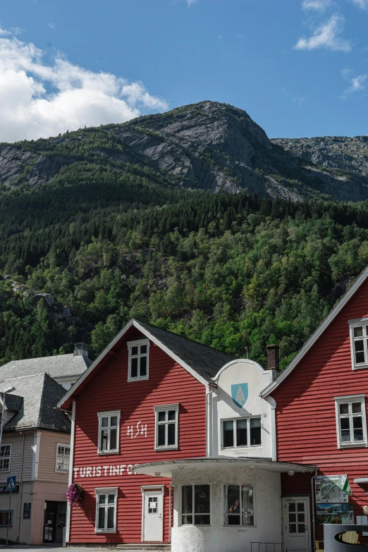 a big red house with mountains in the back ground