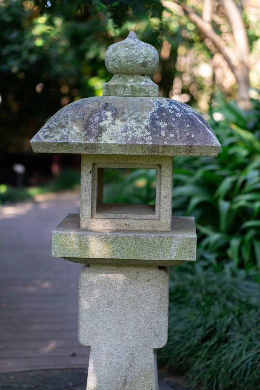 a stone lantern stands in the middle of the park