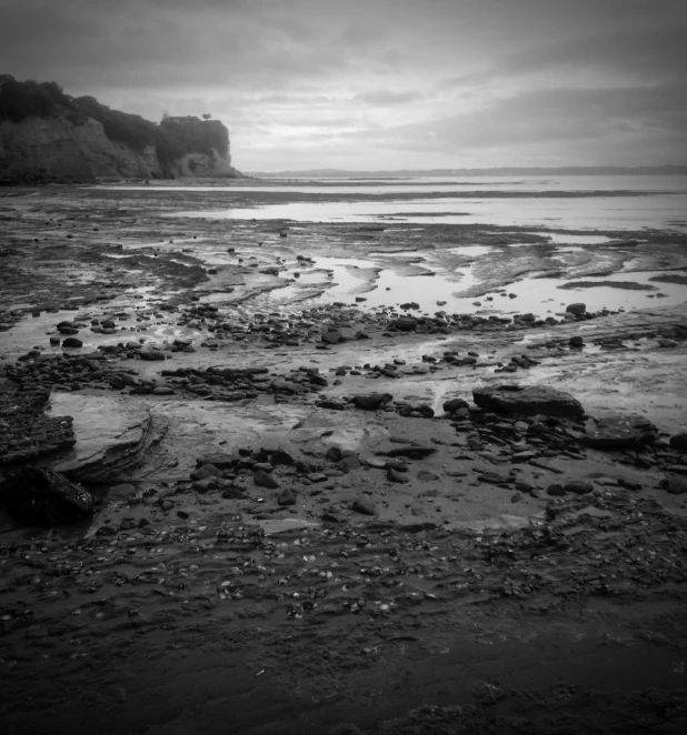 black and white pograph of beach area under cloudy skies