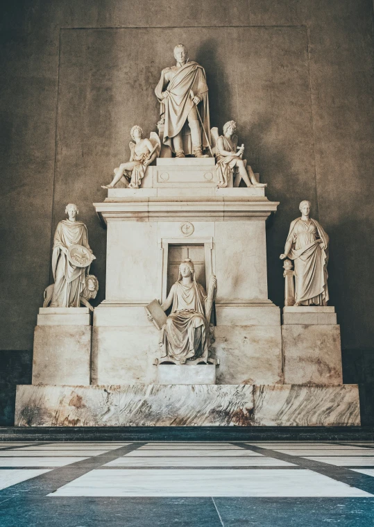 statue with several people in different ages in an indoor setting