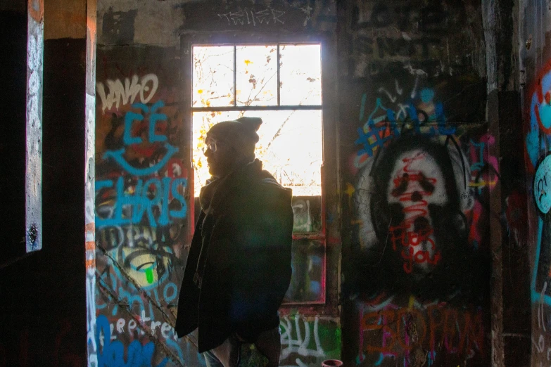 a man walking past an open door with graffiti all over it