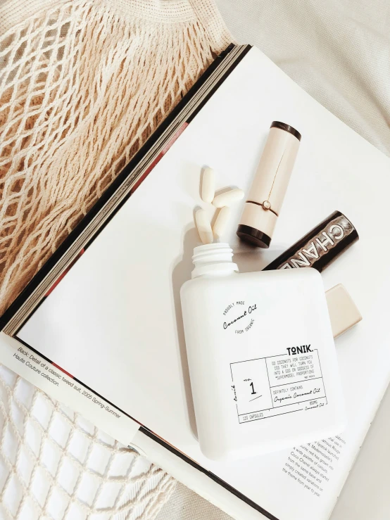 a book on a table with a container and mascara