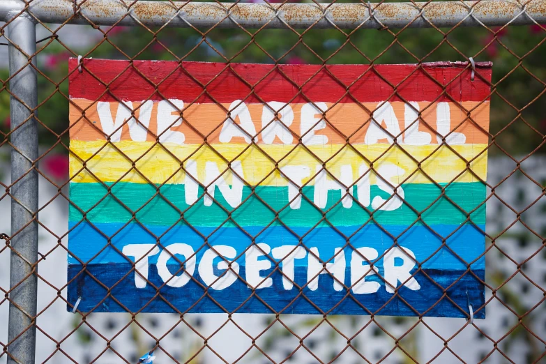 a sign is hung behind a fence with words on it