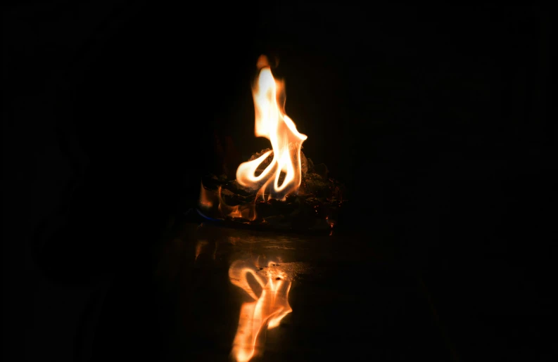 a reflection of a person burning in the dark