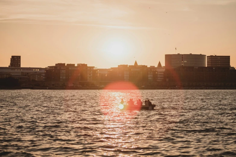 the setting sun reflects off of buildings in the water