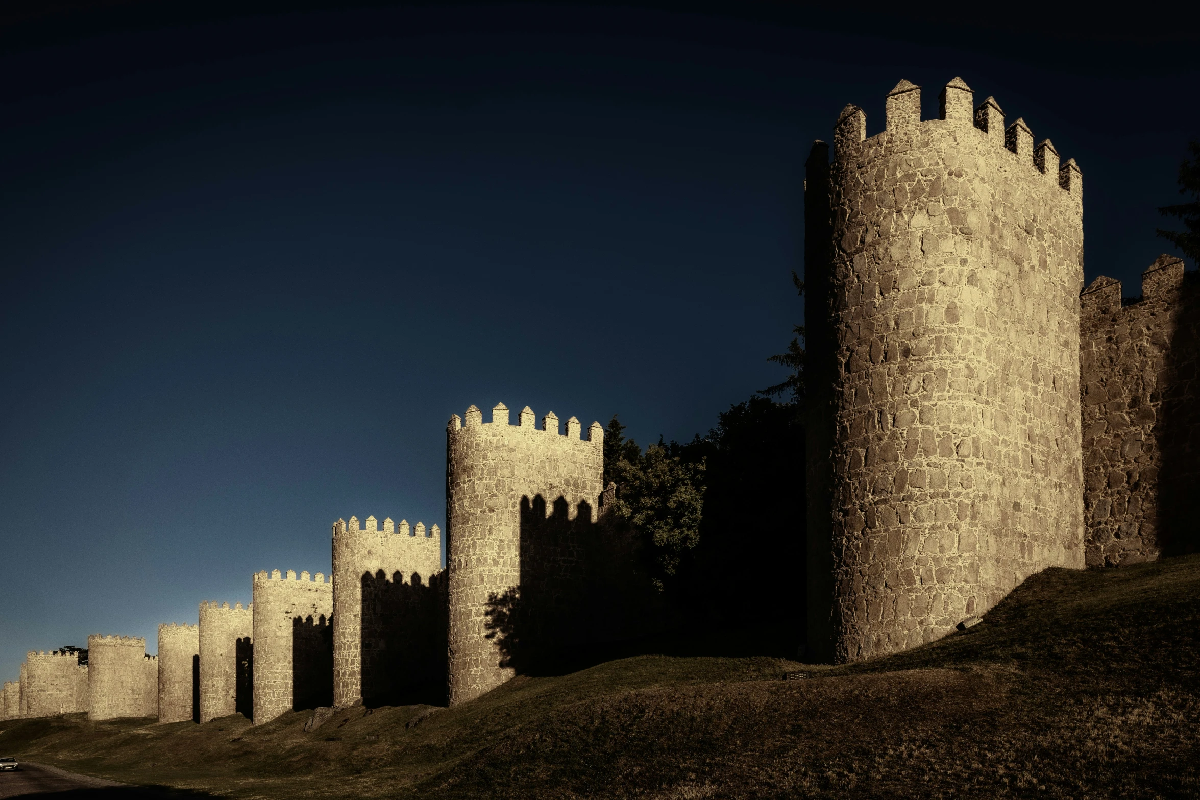 a building sits on a hill near the trees