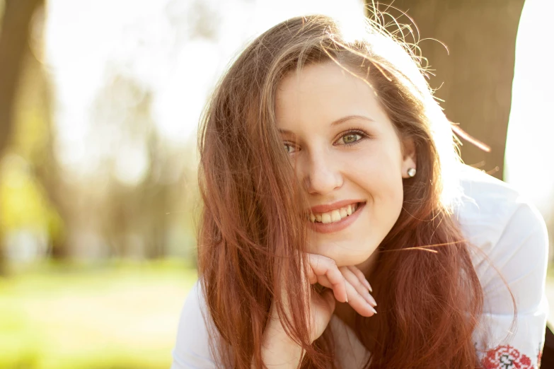 a woman leaning against a tree with her head on the shoulder