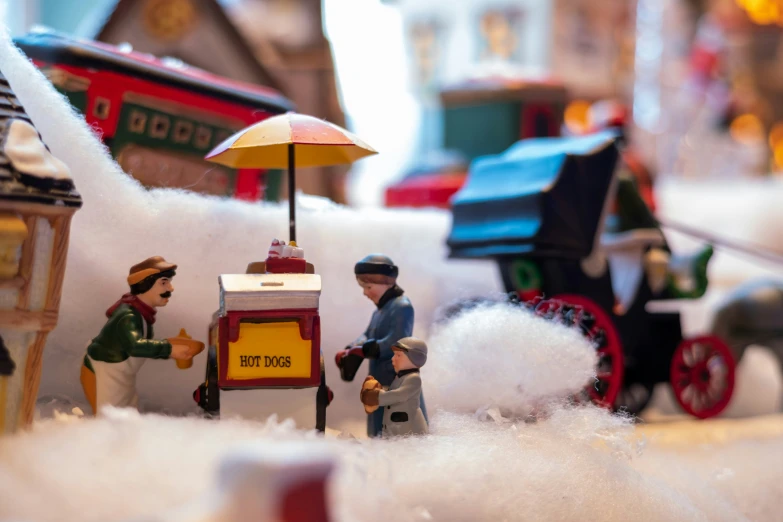 toy figurines in the city street with a miniature firetruck and horse drawn carriage