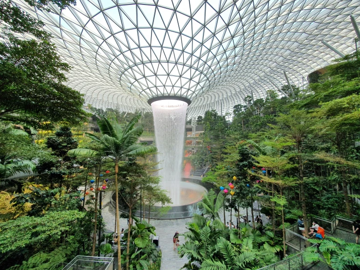 a very tall fountain is set in the center of the park