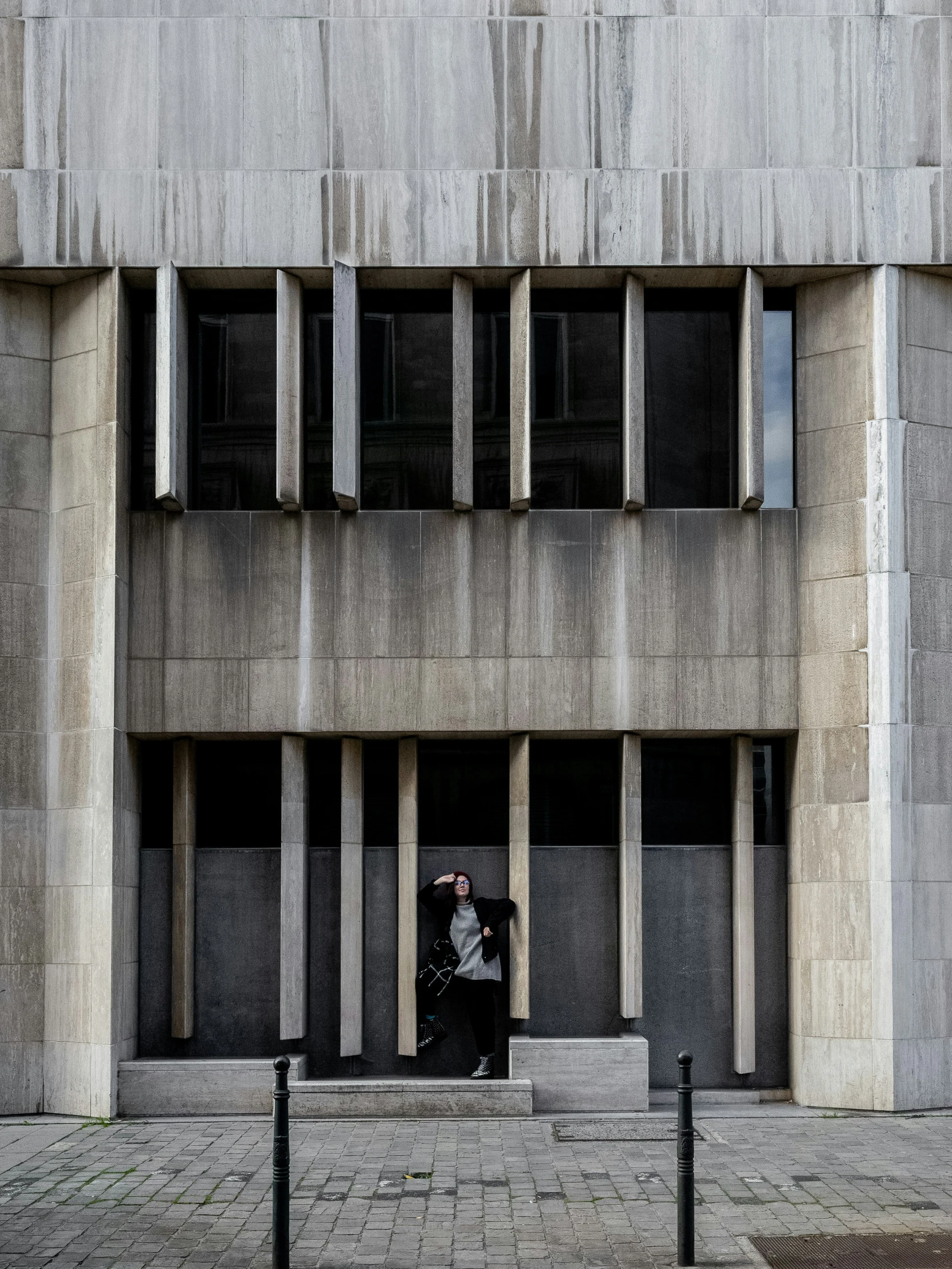 an old gray concrete building that has been partially obscured by metal bars