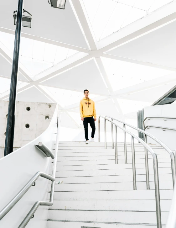 a man is walking up some stairs wearing a yellow jacket