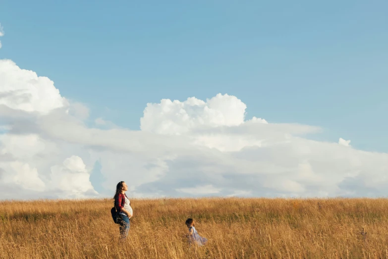 two people on top of a large field flying a kite