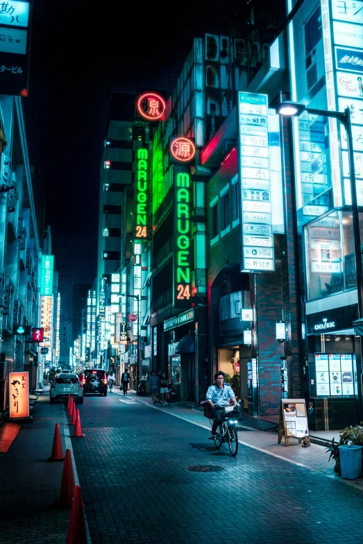 a city at night time with a person riding a bike