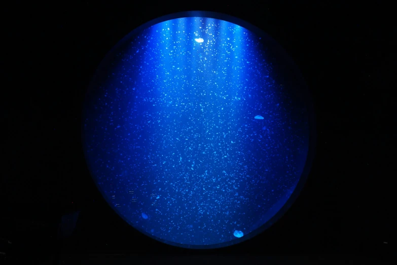 a dark background with a round blue thing in the center