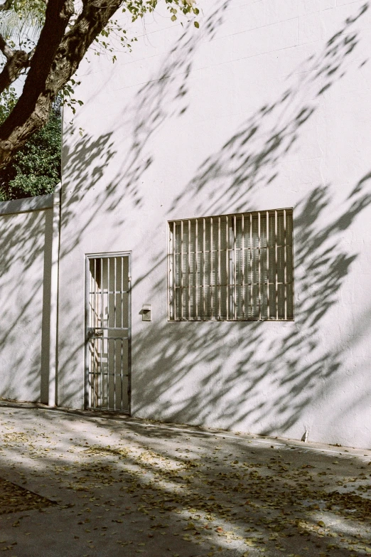 a tall white building with a small barred window