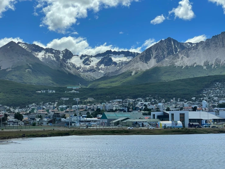 a city sitting next to a lake surrounded by mountains