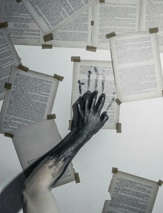 several hands that are sticking out from many opened books