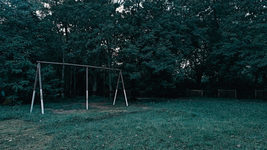 there are several swings in a field in the dark