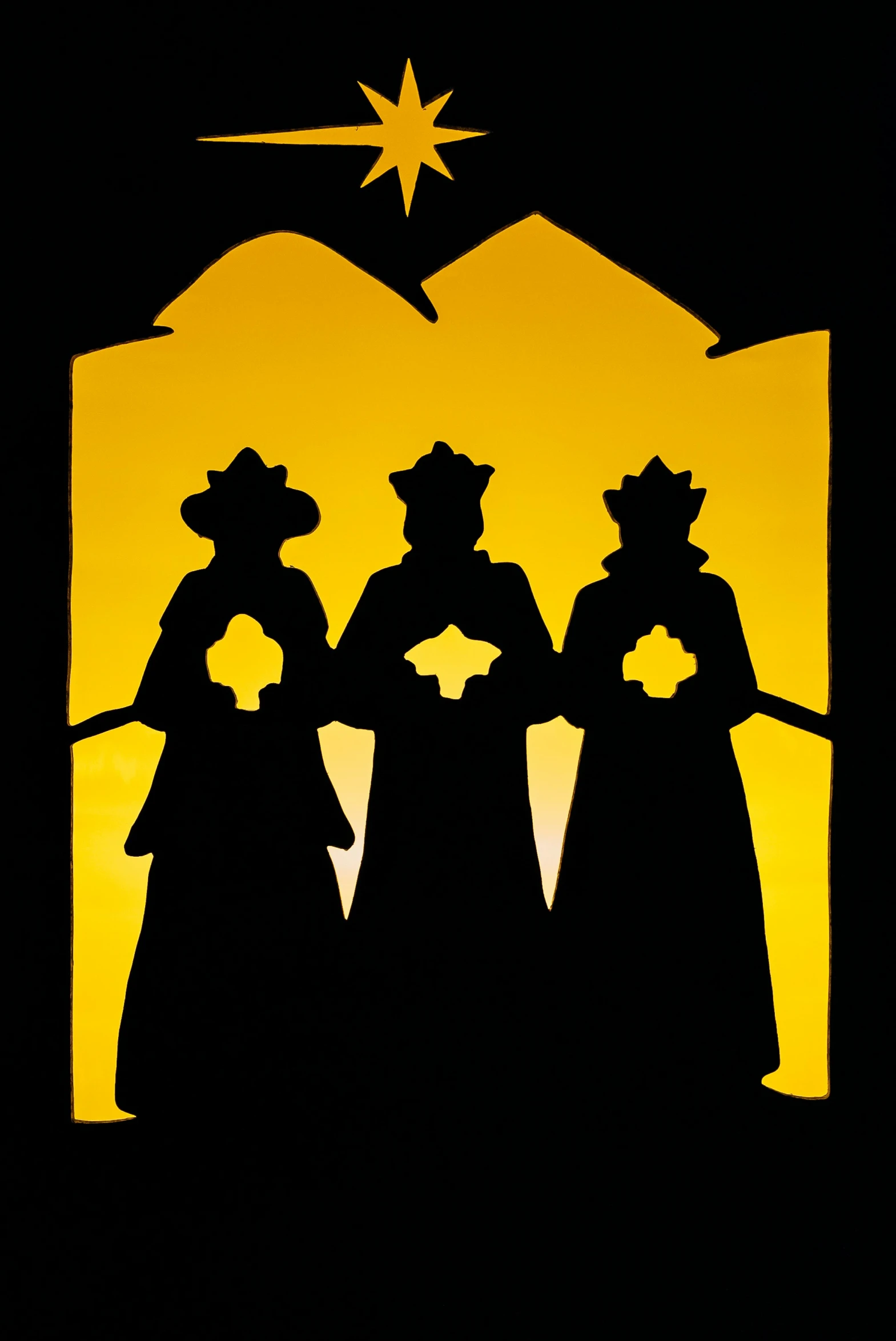 a christmas scene with the three wise men silhouetted against an orange light