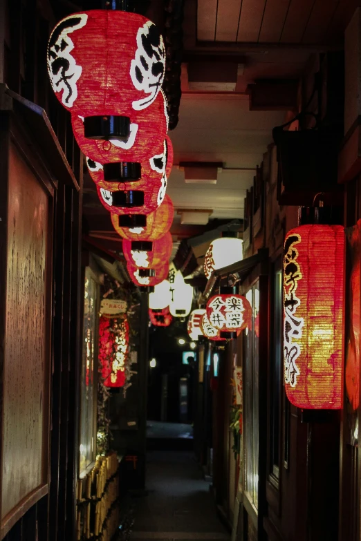 a narrow alley has lanterns on both sides