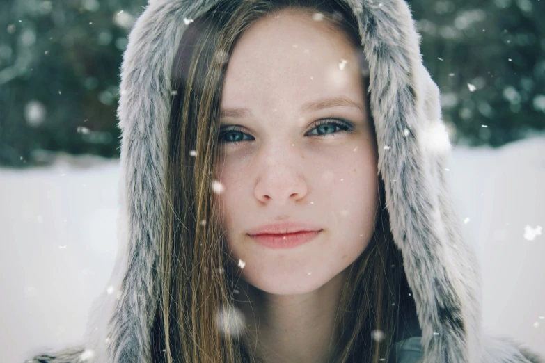 a young lady wearing a furry fur hood over her face