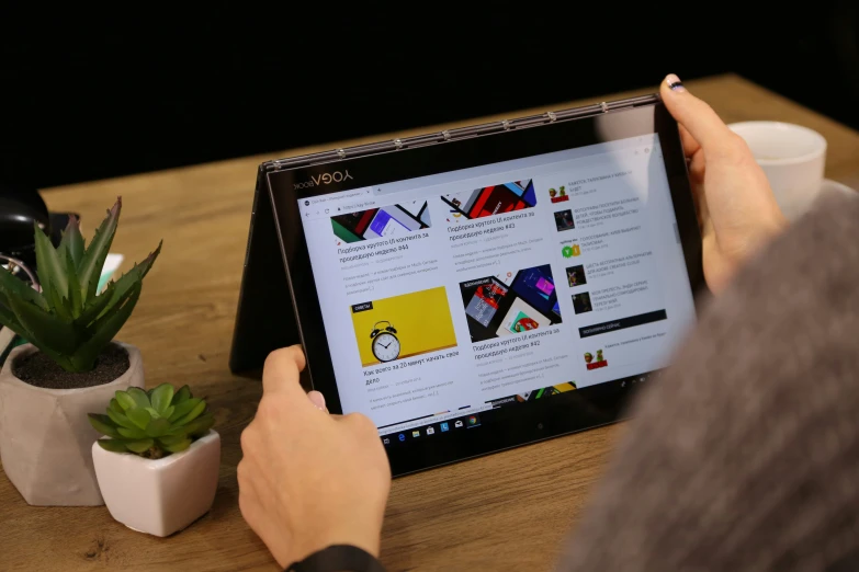 a person is touching on a screen while sitting at a desk