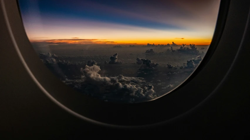 the view out an airplane window at a sunset